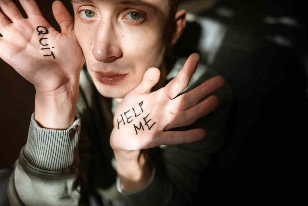 Urgent mental health support young man with "help me" written on his hands, seeking emotional help and mental health awareness, mental health crisis, stress, anxiety, depression.