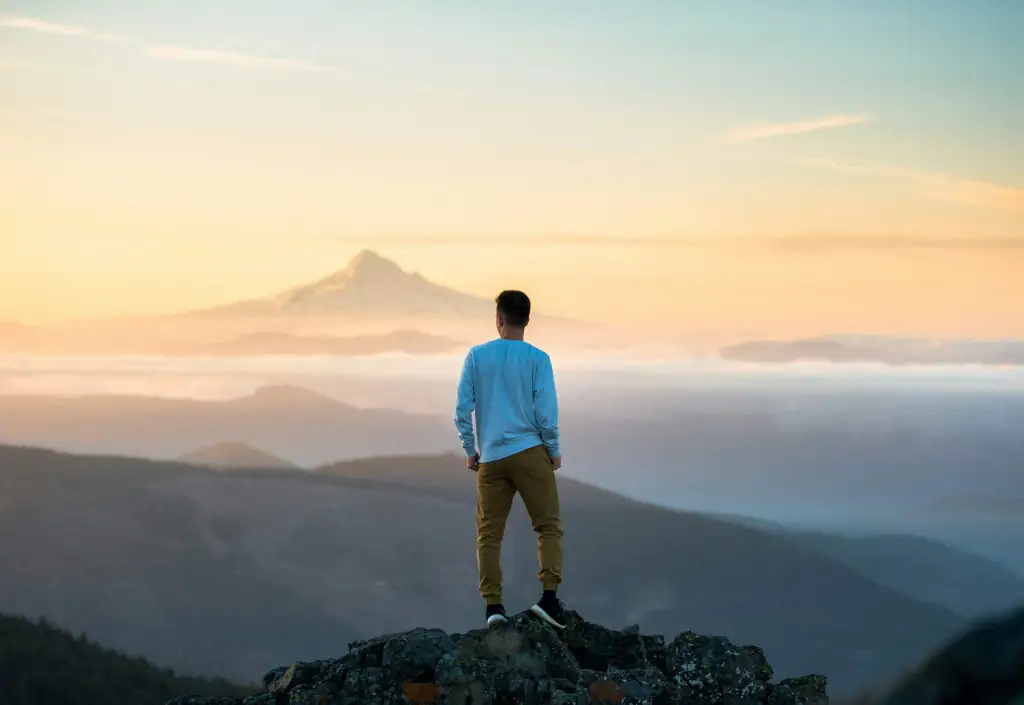 a man standing at the top of the mountain