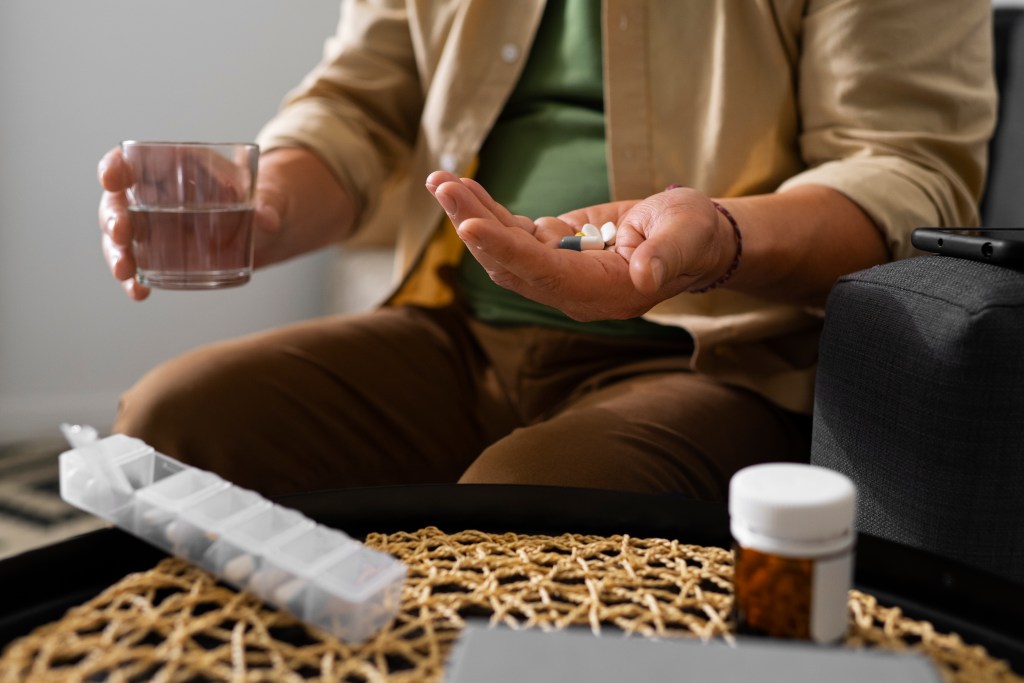 portrait older man taking his pills home